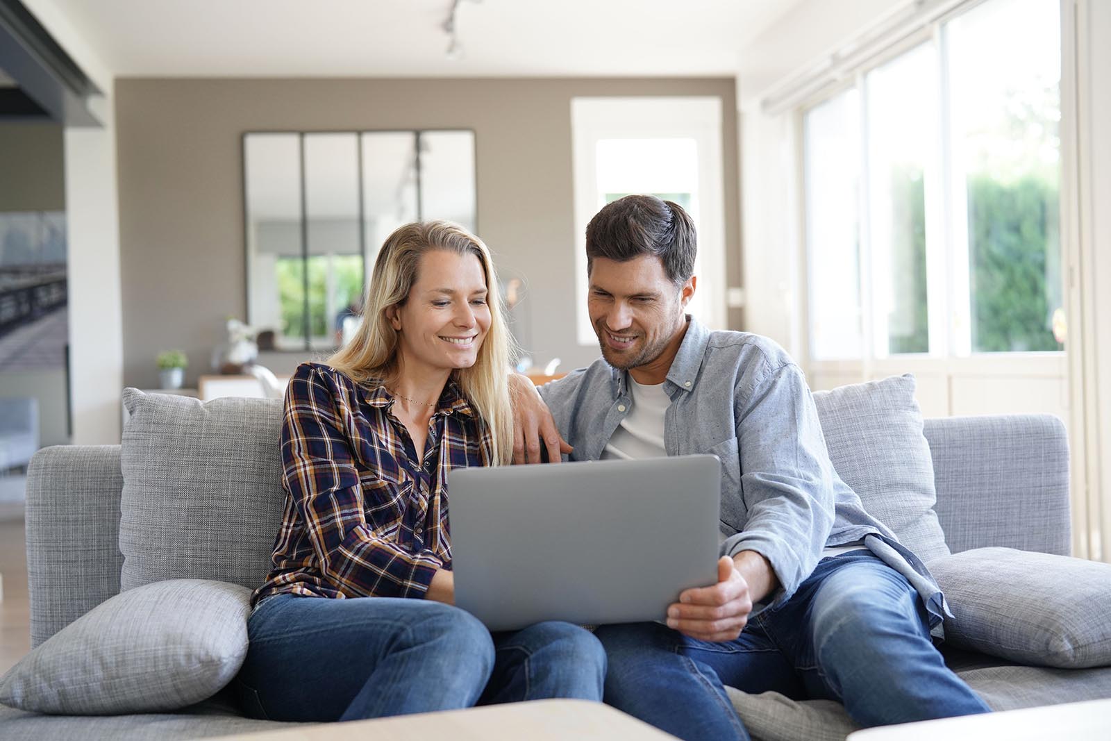 cheerful couple at home using laptop